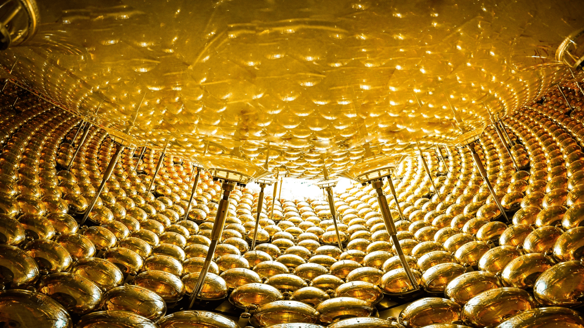 ** Technologist in inflatable raft inside massive underground neutrino detector filled with glowing blue water
