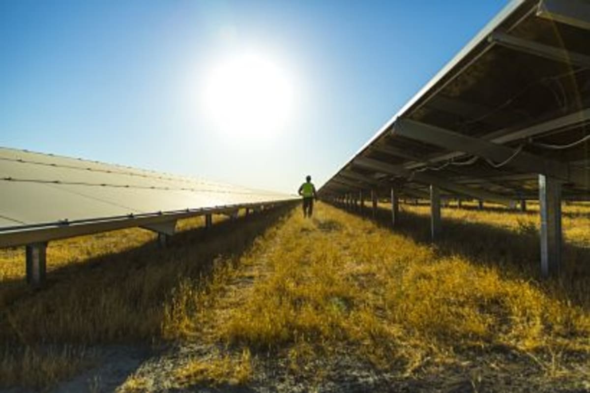 Solar panel array with battery storage facility in Chilean countryside under bright blue sky