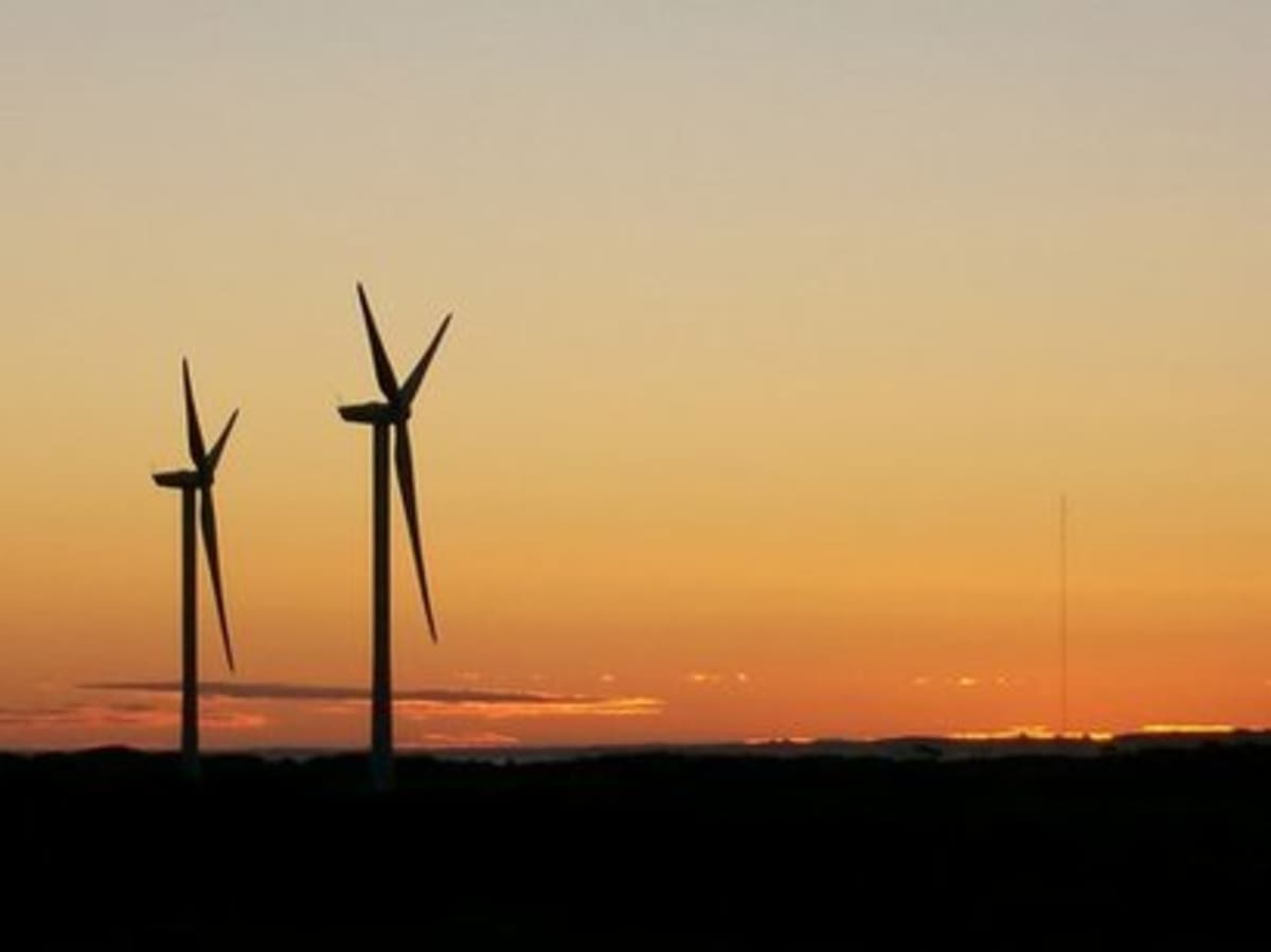 Modern wind turbines standing tall in wind farm generating renewable energy for data centers