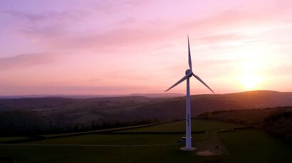 Wind turbine standing tall against blue sky in rural North Cornwall farmland