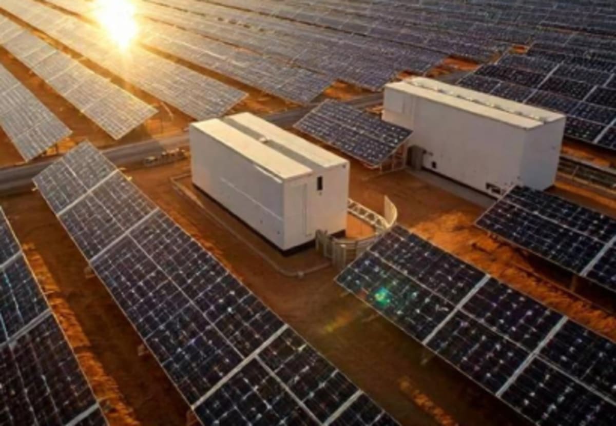 Large scale solar panel array with battery storage facility in rural Australian landscape under blue sky