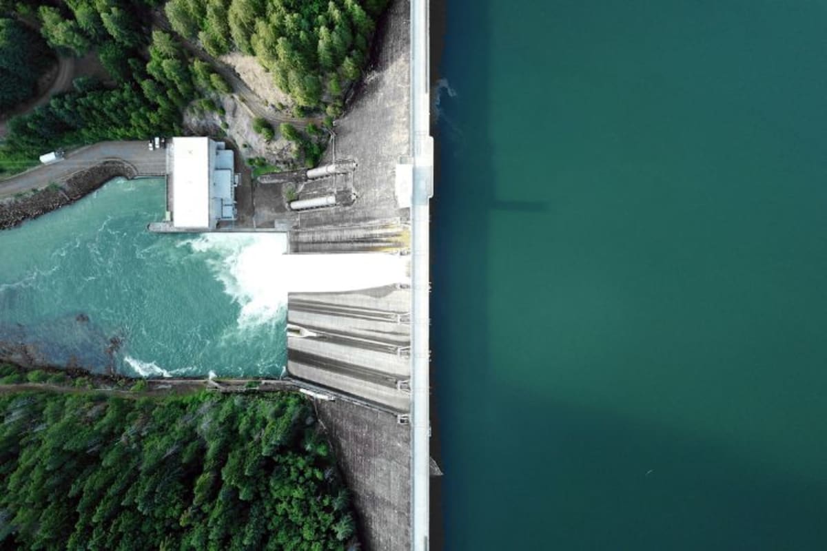 Hydropower dam with water flowing through turbines generating renewable electricity