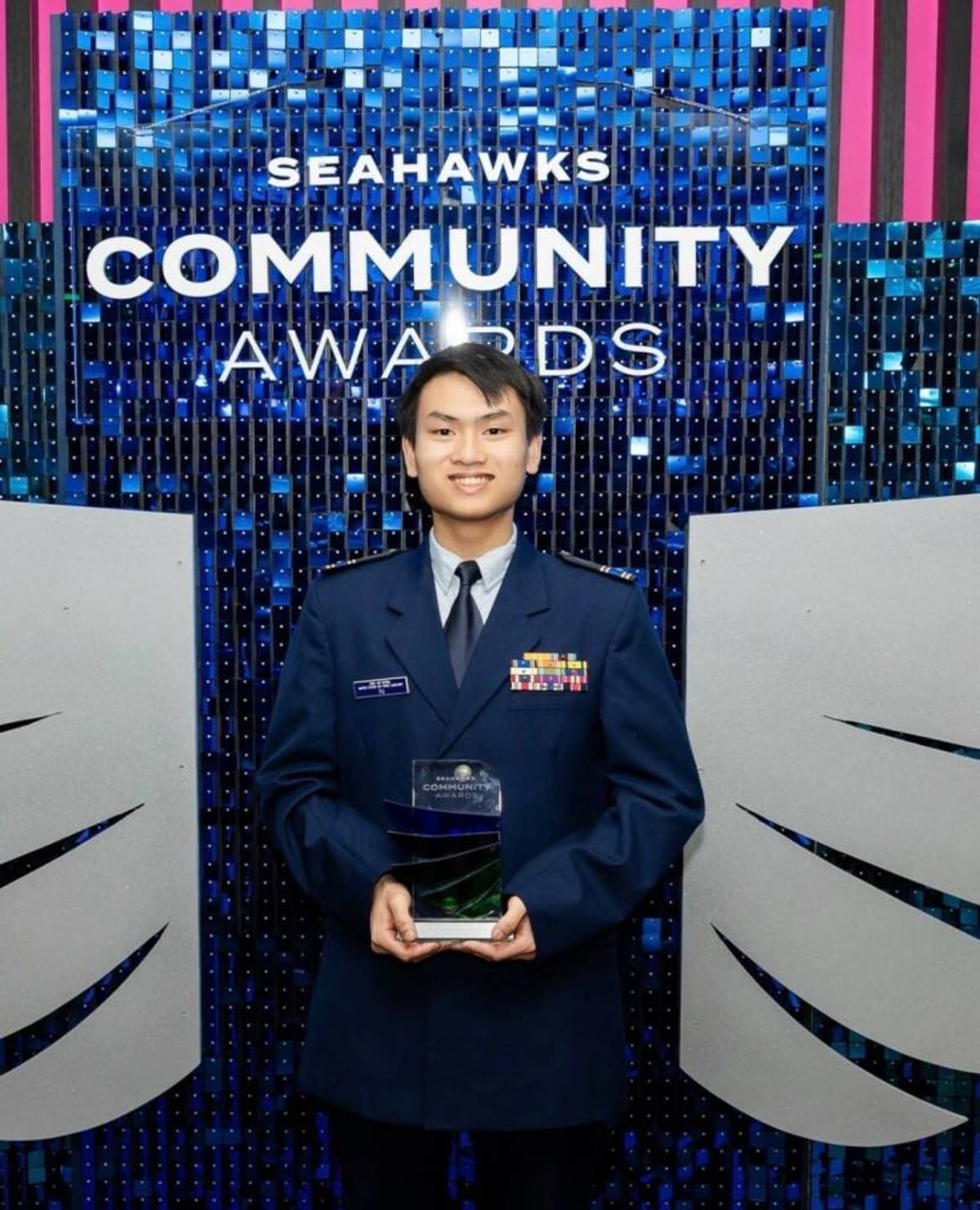 ** Khiem Tu receiving ten thousand dollar scholarship check from Seattle Seahawks at Lumen Field