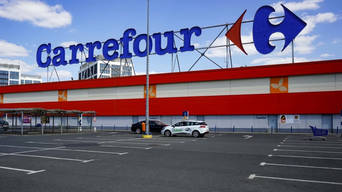 Carrefour supermarket exterior with shopping carts and customers entering store entrance