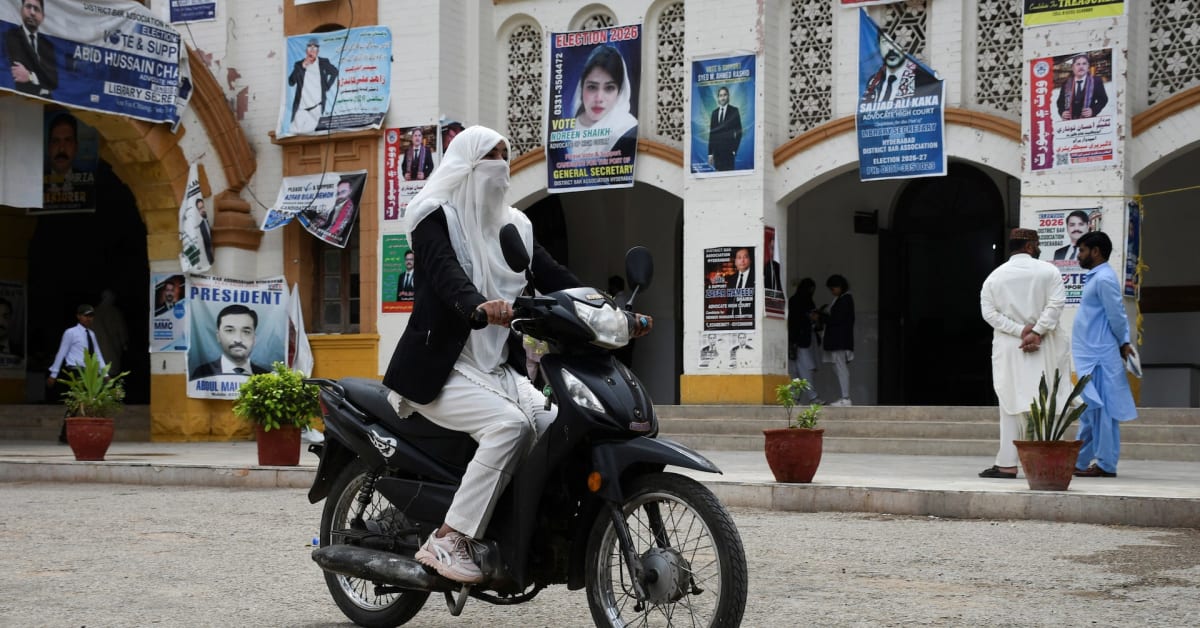 Pakistani worker assembling electric motorcycle on factory production line in Lahore