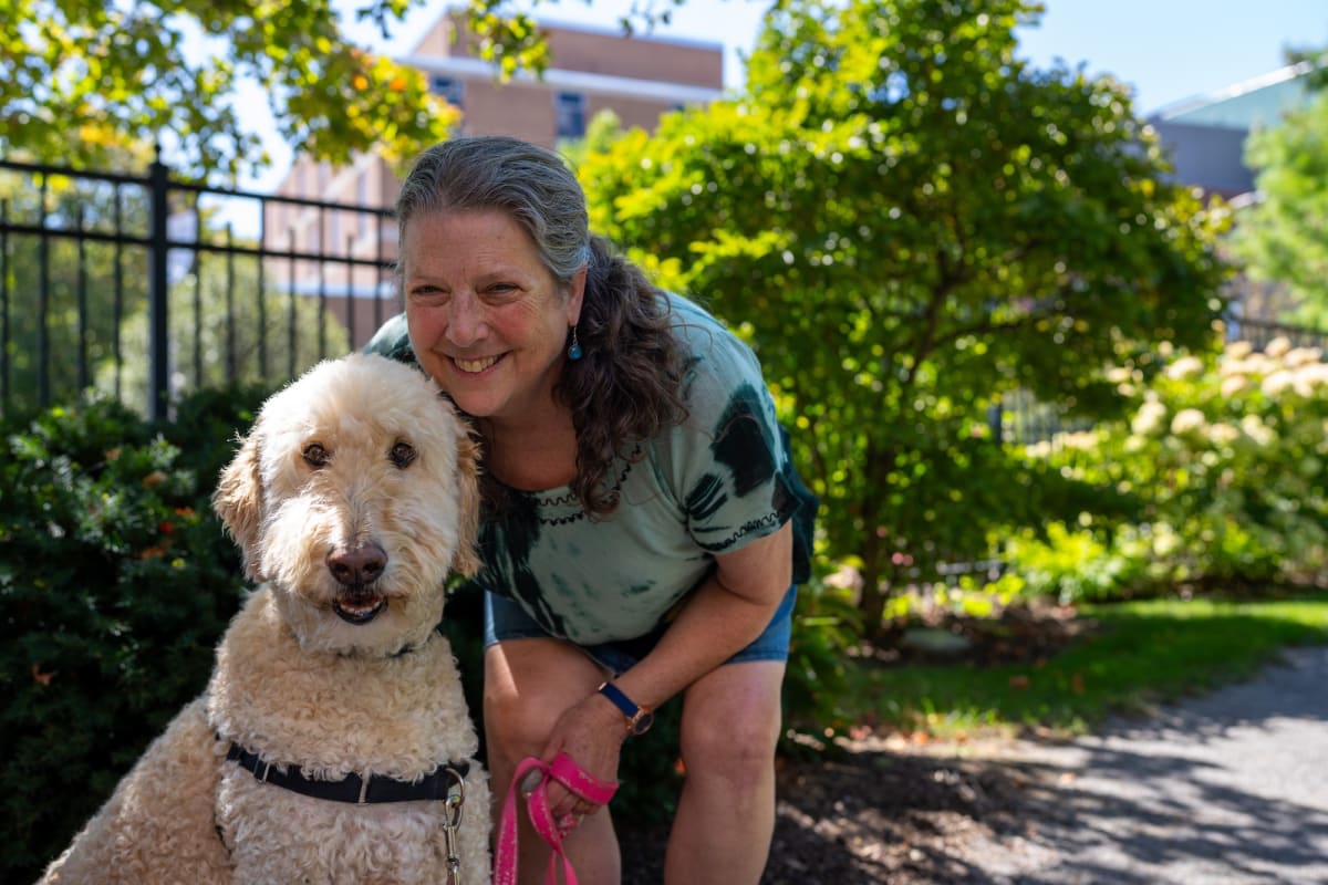 Smiling ovarian cancer survivor Julie Francisco with her therapy dog Morty