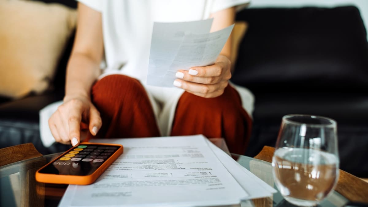 Irish family reviewing household budget together at kitchen table with relieved expressions