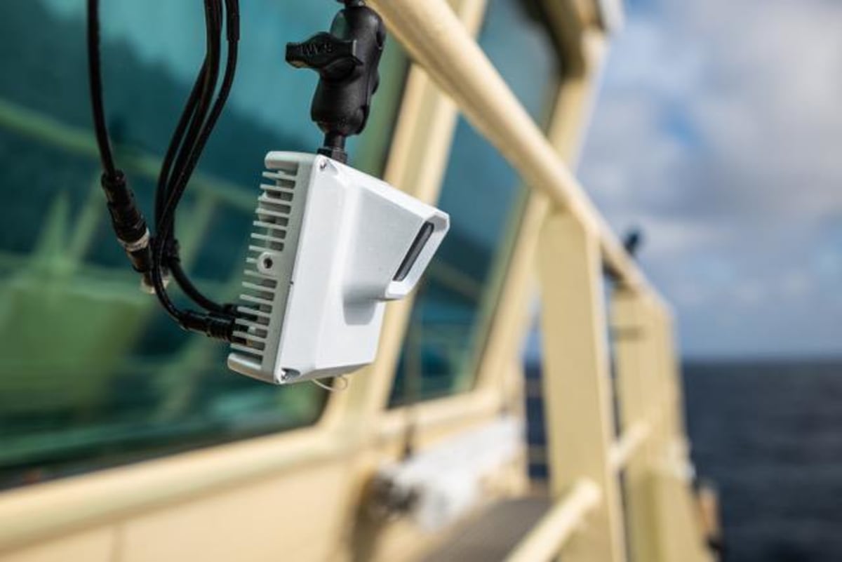 Compact AI camera mounted on sailing vessel railing to detect ocean plastic debris