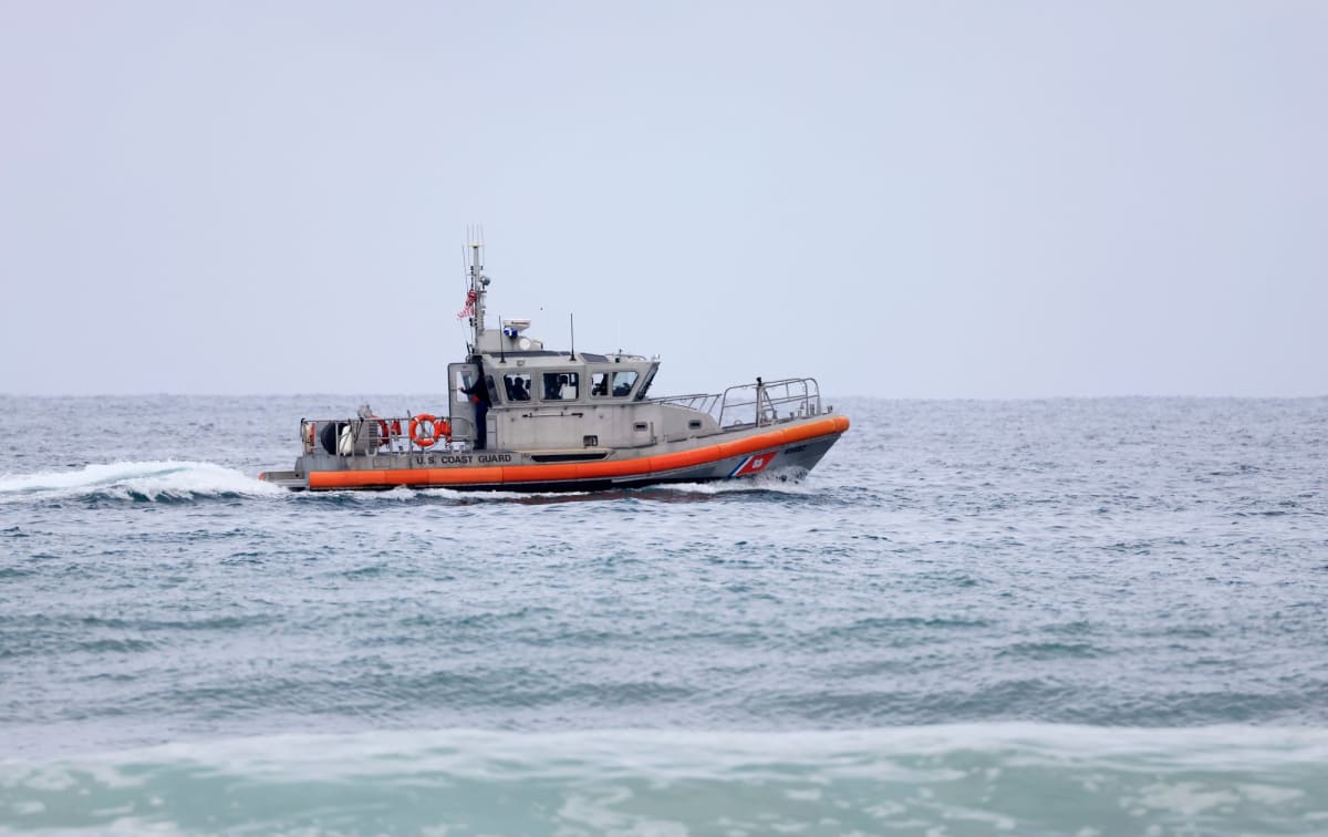Smoke rising from burning sailboat on foggy ocean horizon off San Diego coast