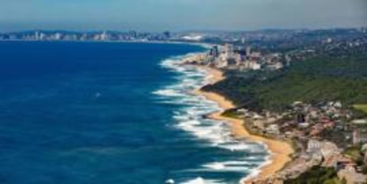 Delegates networking at ocean economy summit with coastal city backdrop in Durban