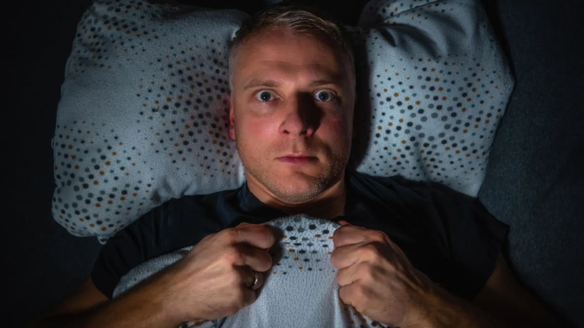 Person sleeping peacefully in bed at night, representing relief from PTSD nightmares