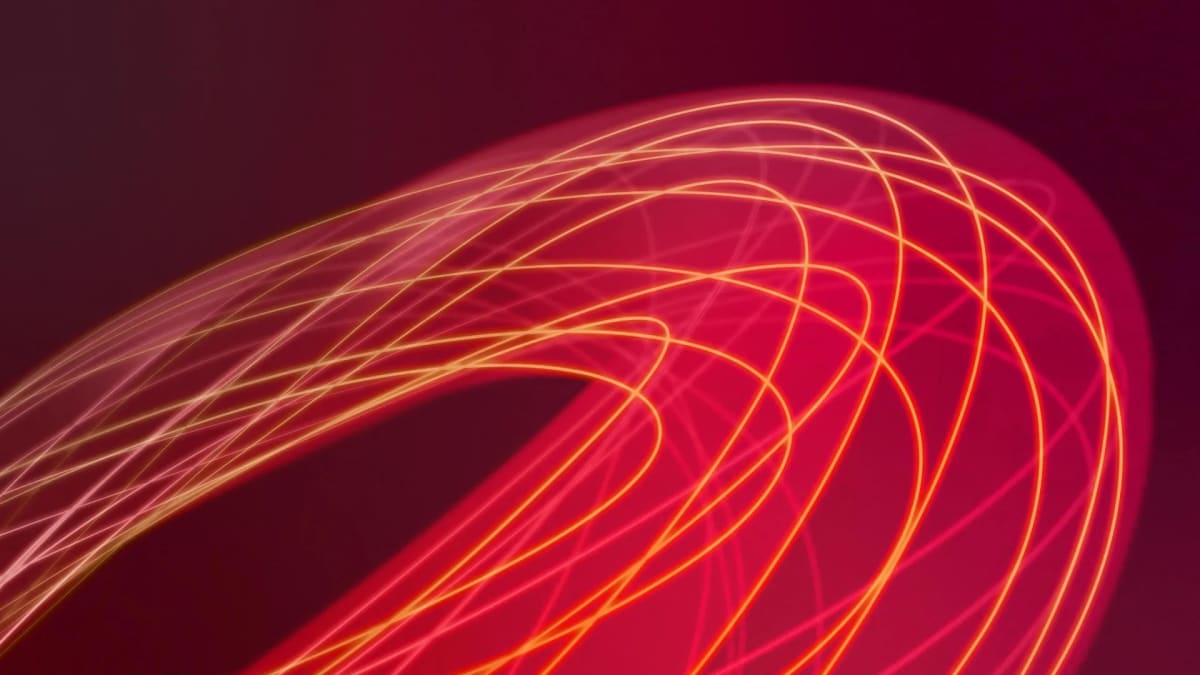 Artistic rendering of glowing plasma particles flowing through doughnut-shaped fusion tokamak reactor