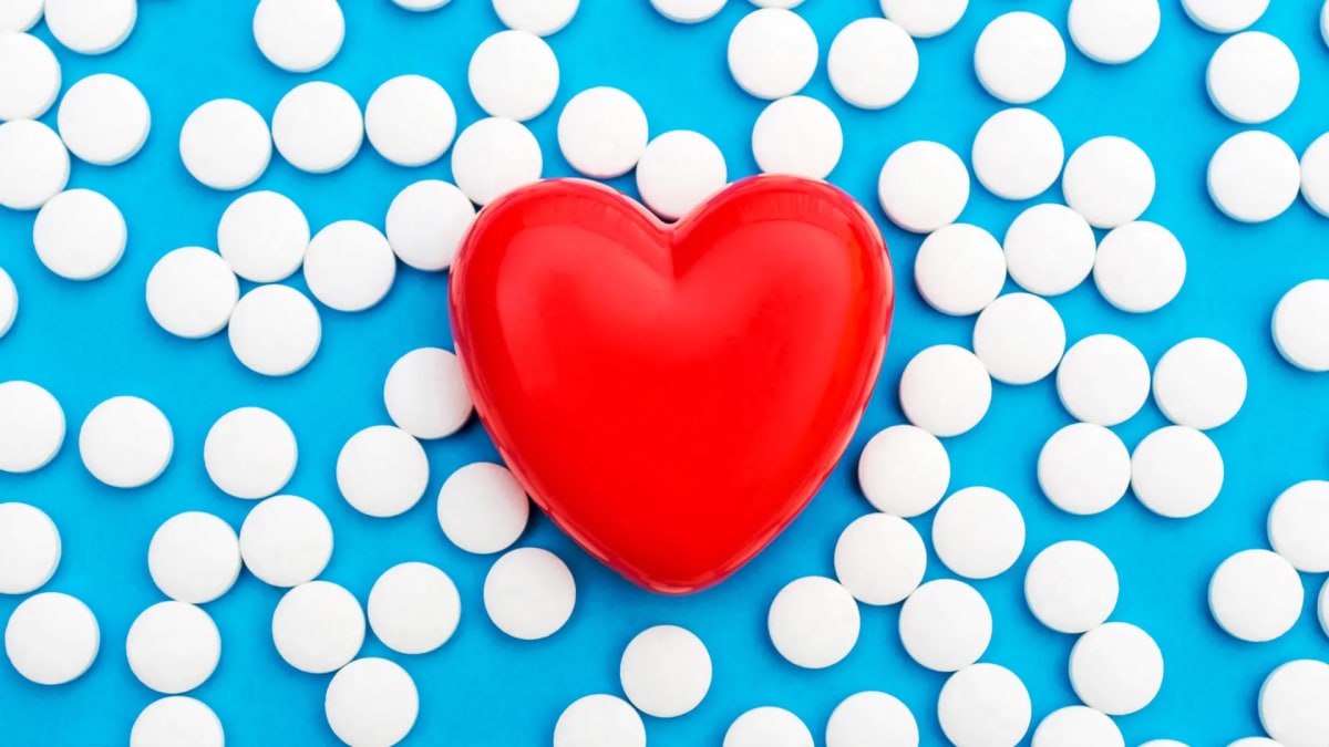 Medical researcher holding small bottle of digoxin pills in modern cardiology laboratory setting
