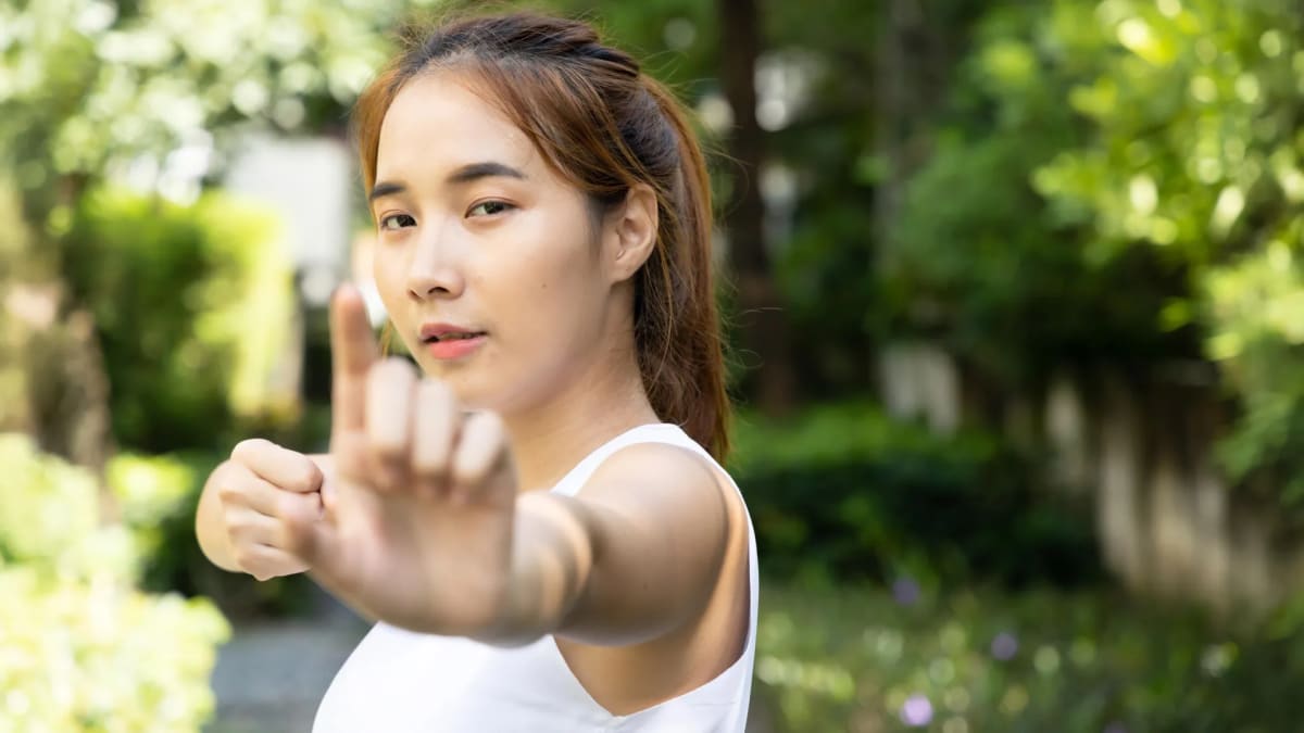 Group of adults practicing gentle baduanjin movements outdoors in community setting