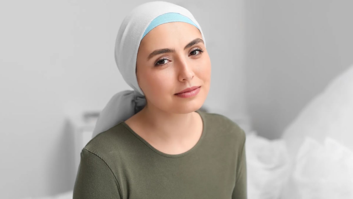 Cancer patient in comfortable clothes doing gentle stretching exercises at home during treatment