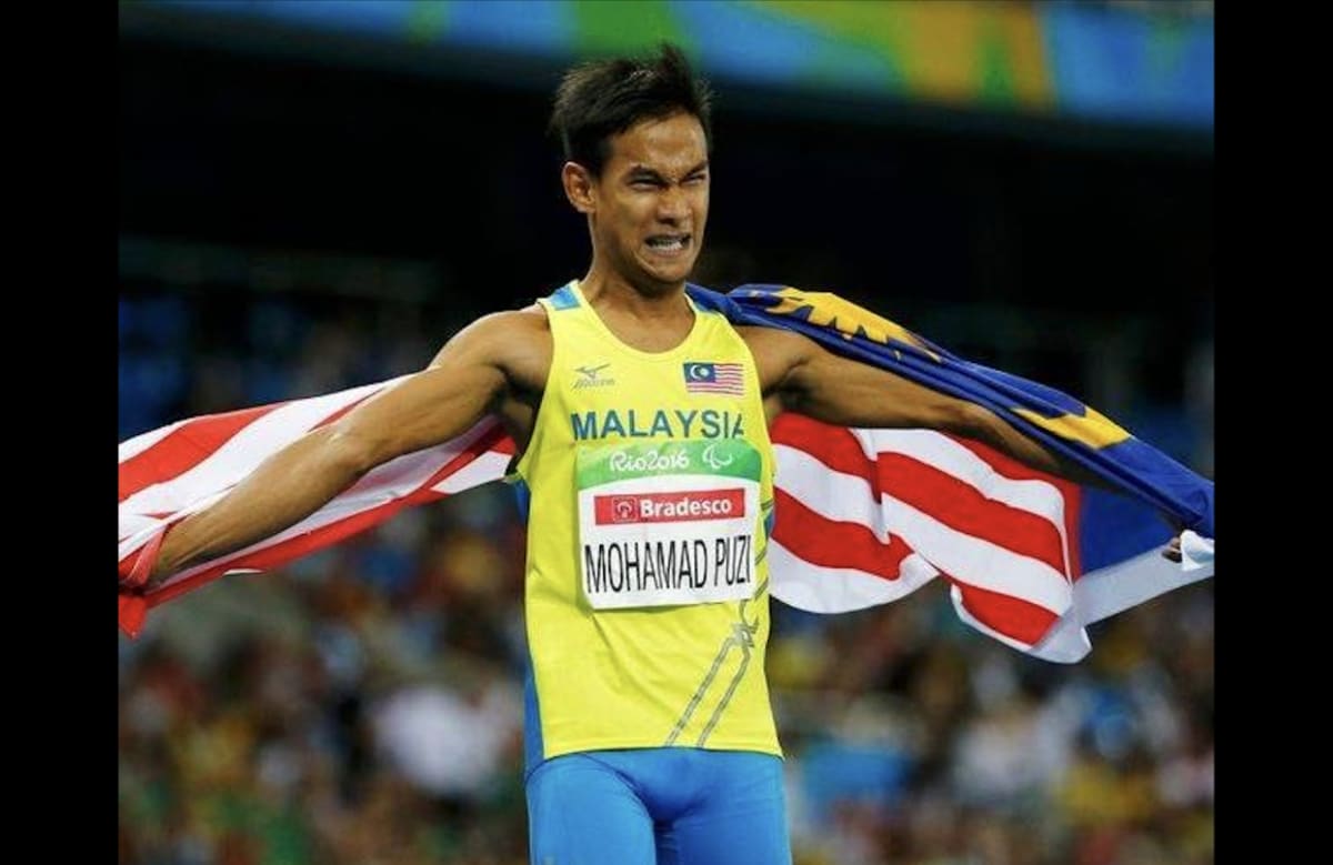 Paralympic sprinter Ridzuan Puzi celebrating on track in Malaysian athletics uniform