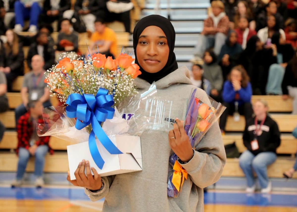 Diverse group of Seattle high school students in graduation caps celebrating with scholarship certificates