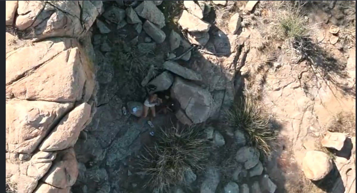 Rescue drone flying over rocky Arizona wilderness terrain searching for injured hiker