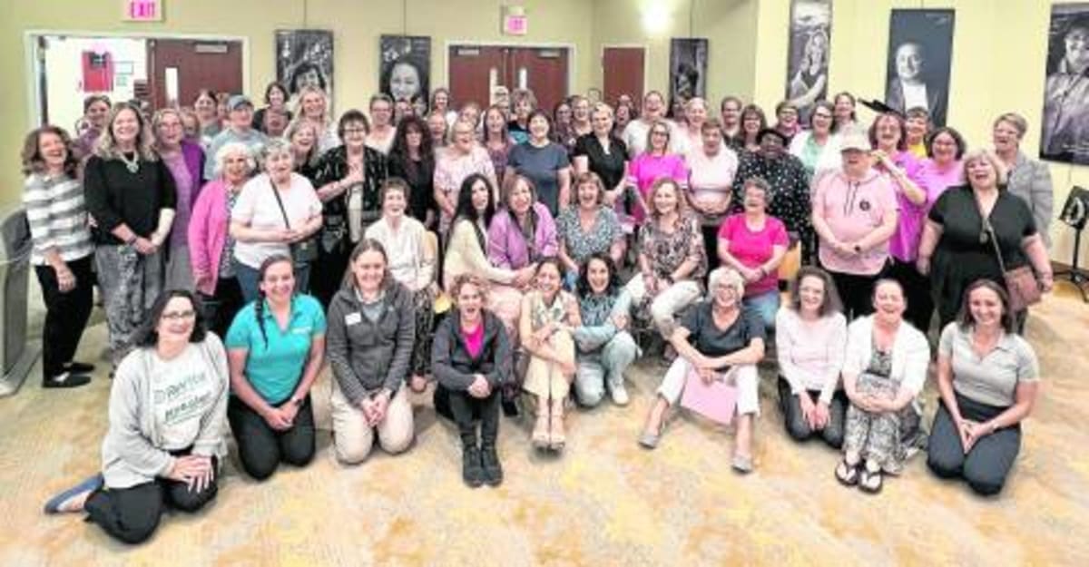 Breast cancer survivors smiling and embracing at Project Self-Sufficiency community celebration event