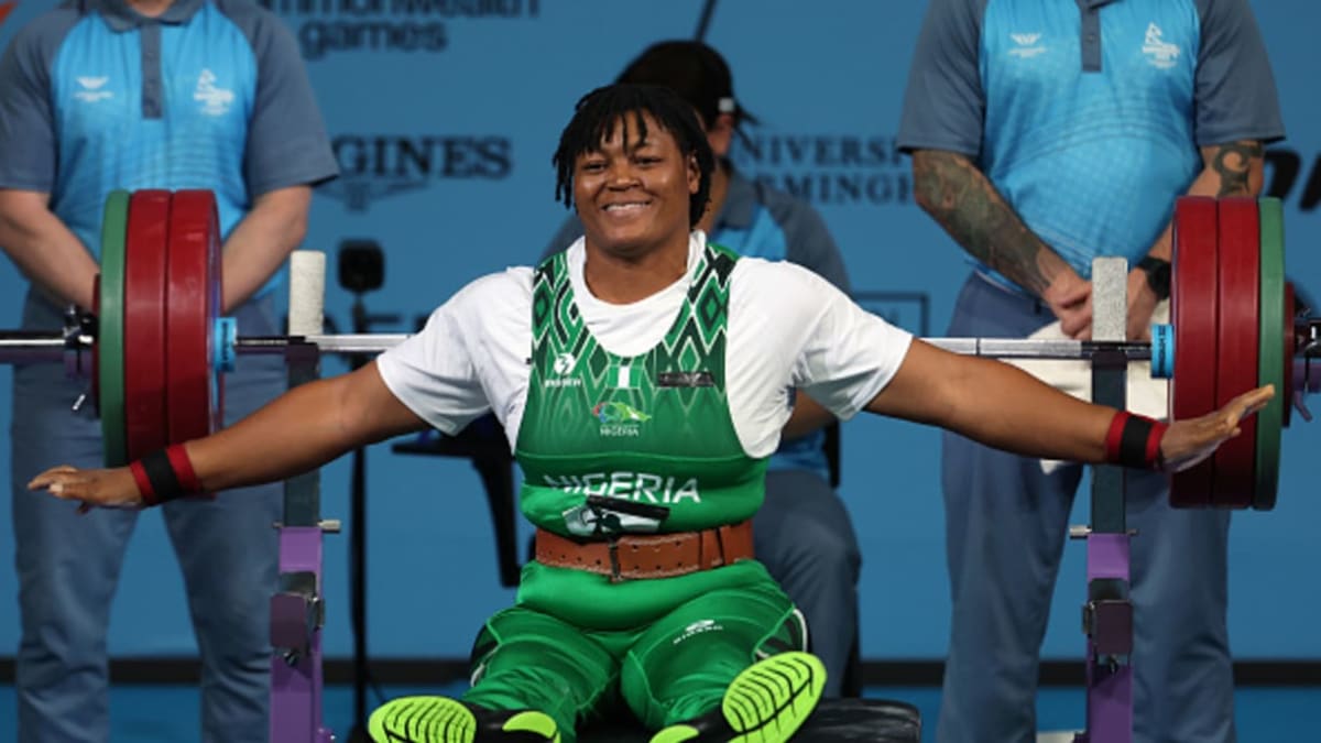 Para powerlifting athlete competing in championship event lifting weights on specialized bench