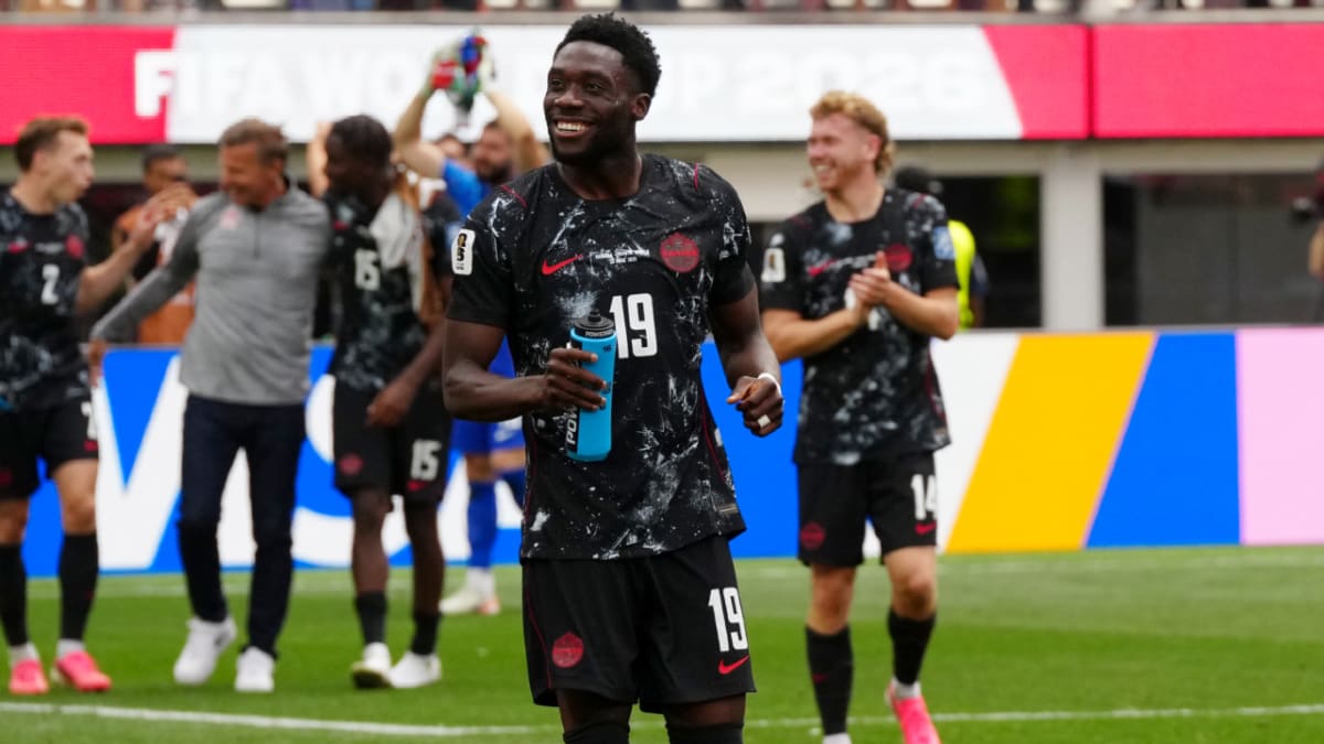 ** Canadian soccer players celebrating historic World Cup knockout stage victory on field