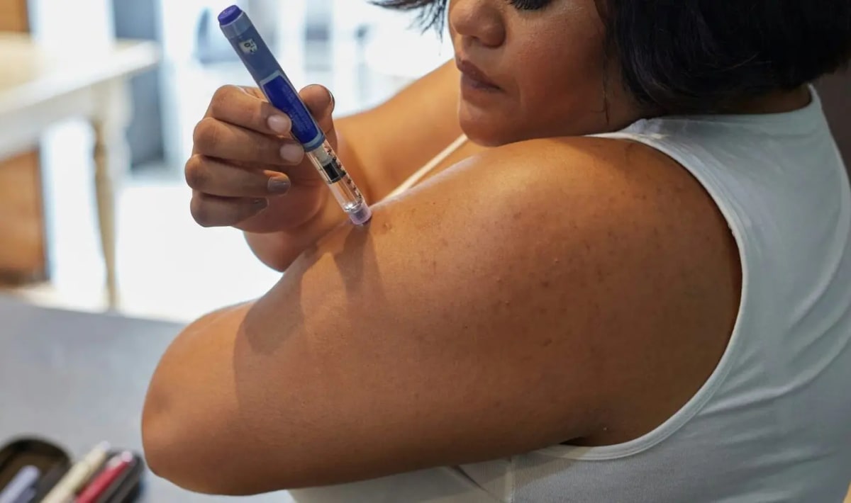 Medical professional holding weight loss medication injection pen in clinical setting