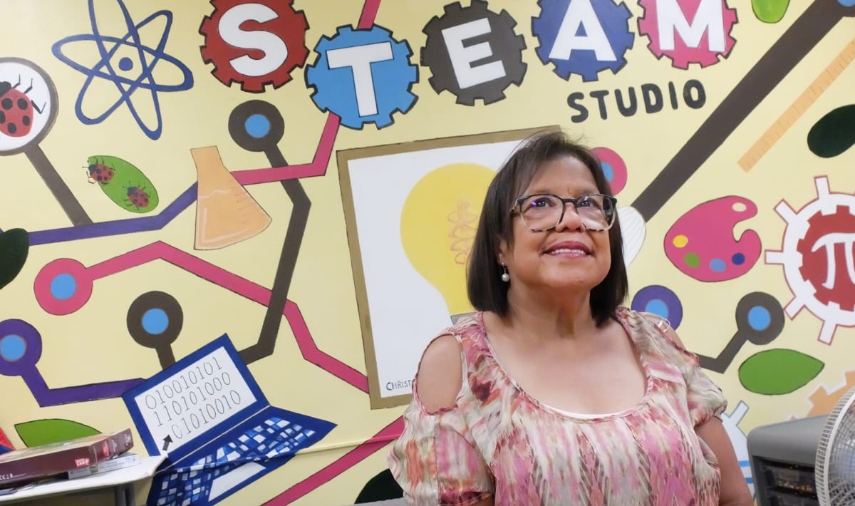 Carmen Kahiu smiling at the Hazleton Integration Project computer lab where she volunteers