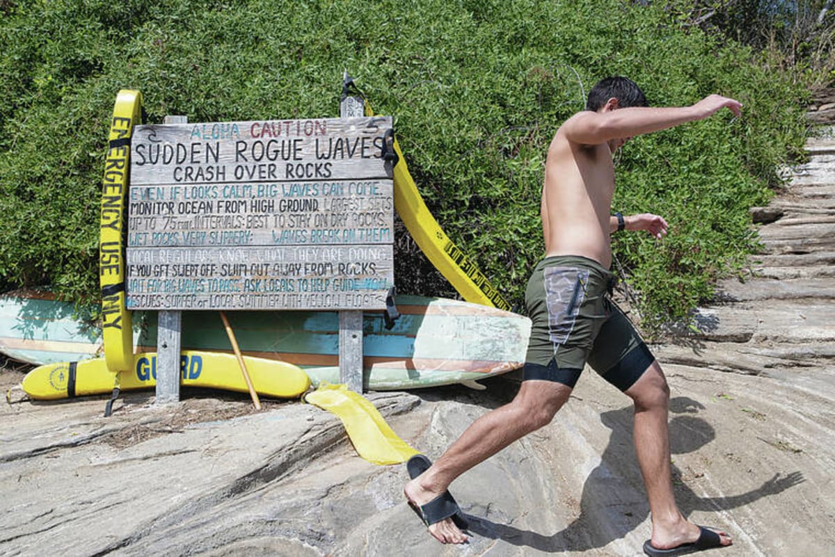 ** Bright yellow rescue tube mounted on stand at China Walls coastal cliffs in Hawaii