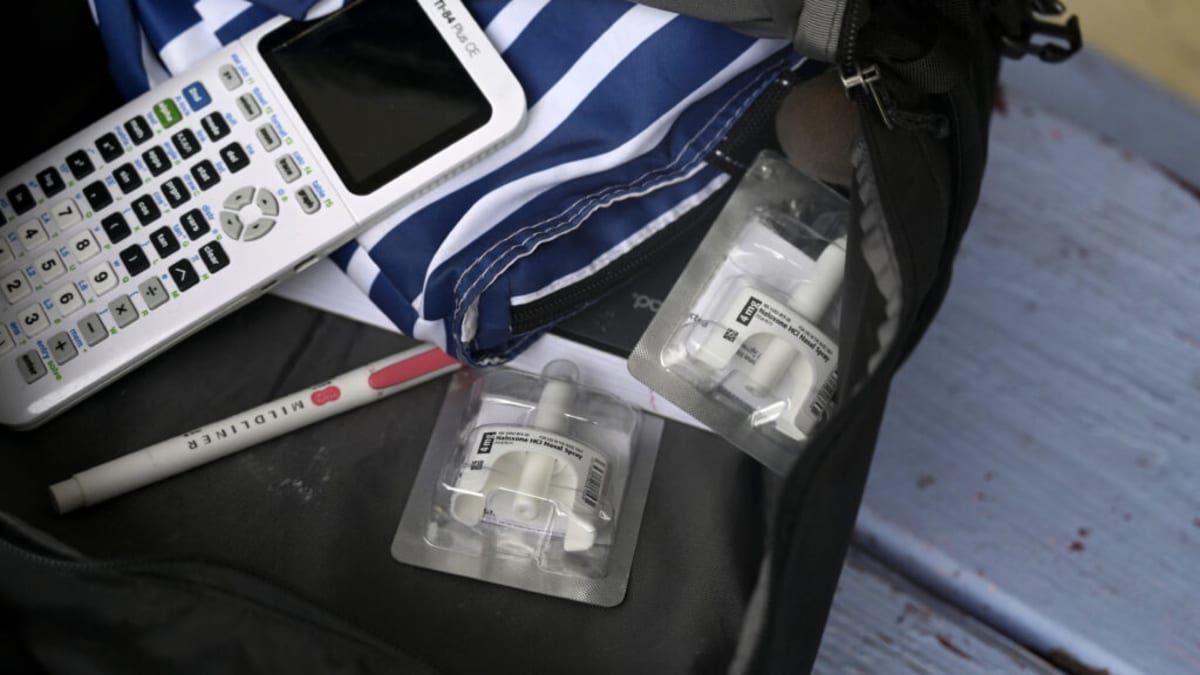 Healthcare worker holding naloxone overdose reversal medication representing life-saving treatment efforts