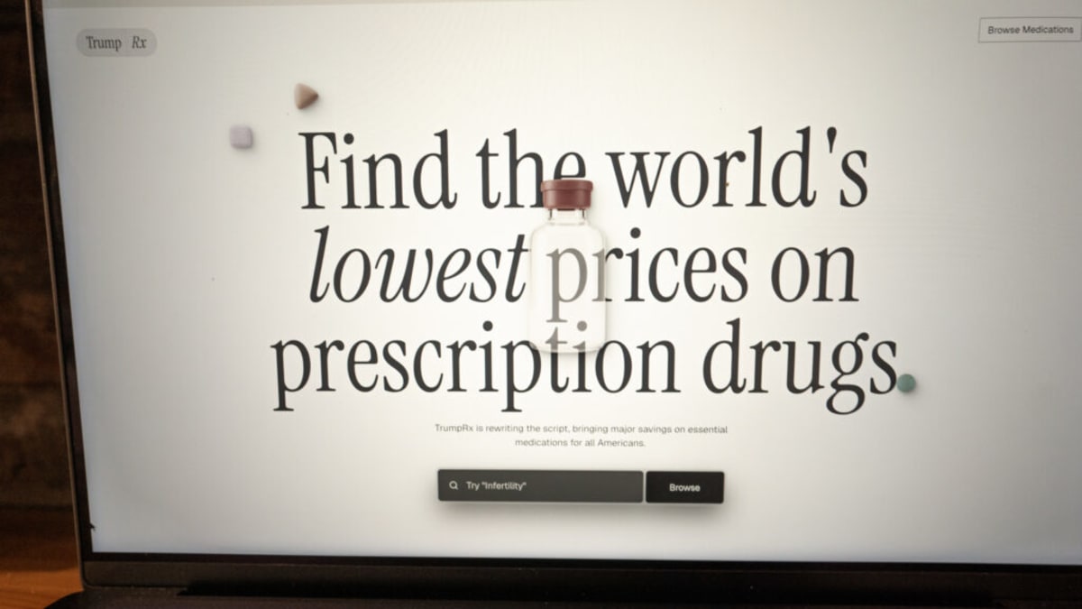 Person reviewing prescription medication prices on smartphone at pharmacy counter with bottles visible