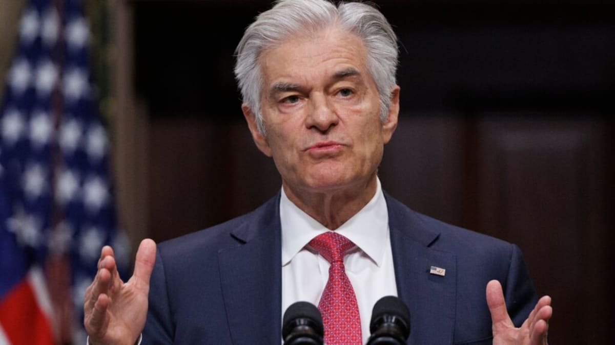 Health policy analyst reviewing data charts and documents at desk with computer
