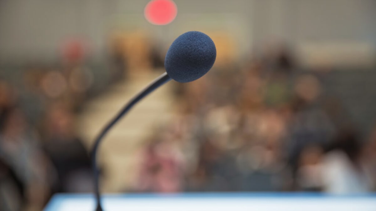 Diverse group of people engaged in respectful conversation at professional conference setting