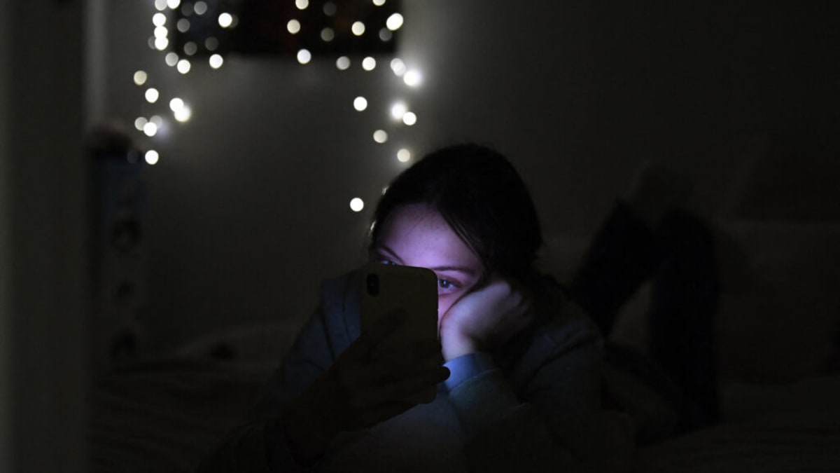Person holding smartphone displaying 988 crisis hotline number on screen with supportive message
