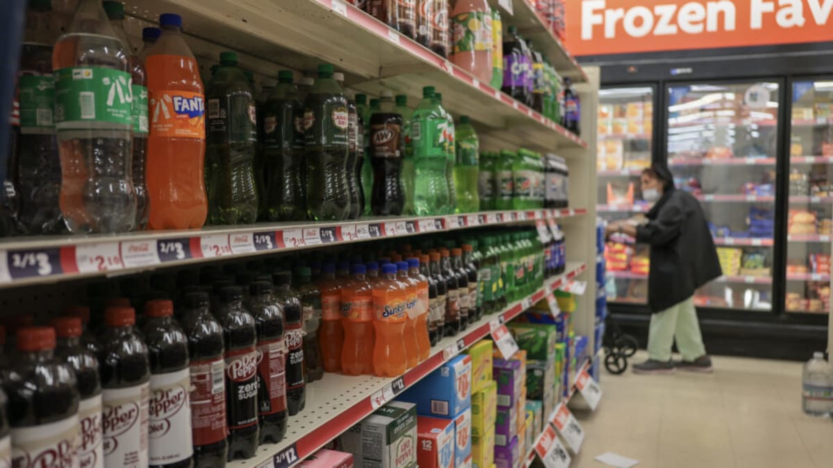 Shopping cart in grocery store aisle with healthier beverage alternatives to soda