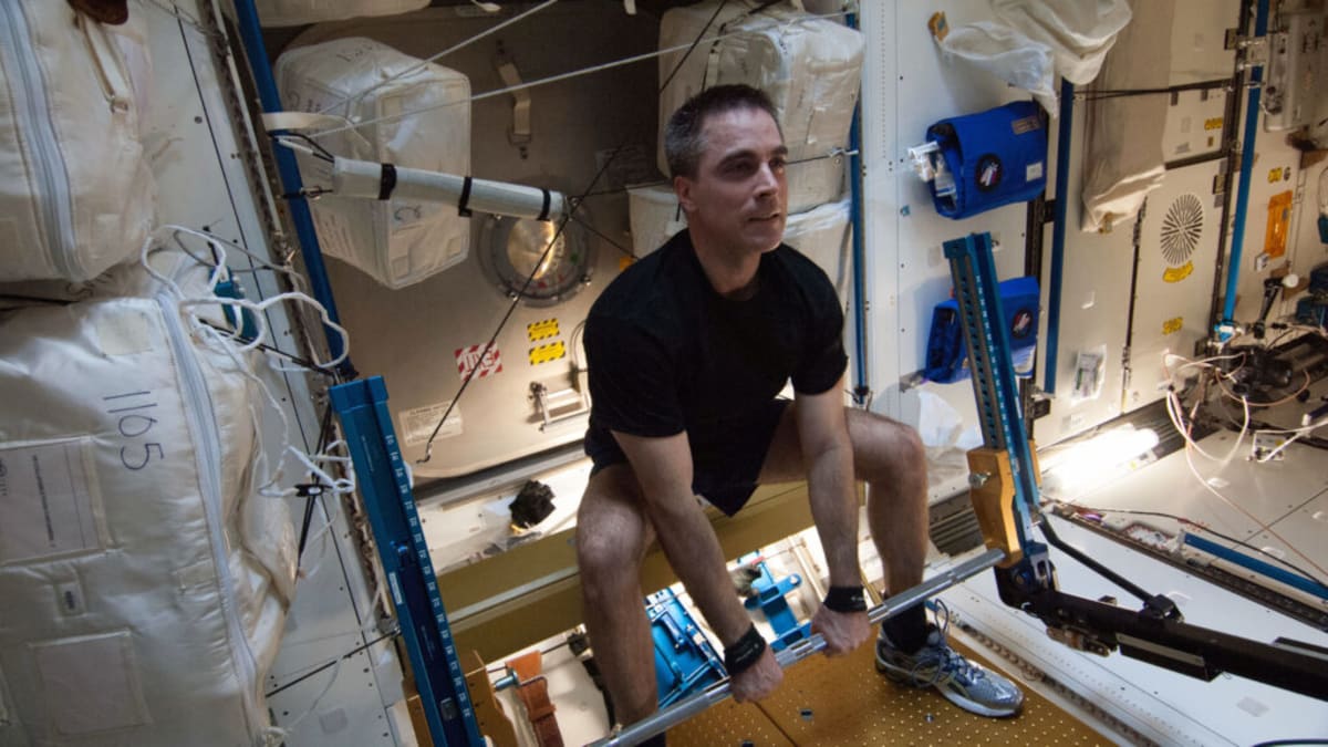 Astronaut exercising on specialized equipment aboard the International Space Station in microgravity
