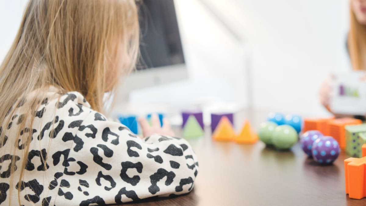 Young child working with therapist during early intervention developmental assessment session