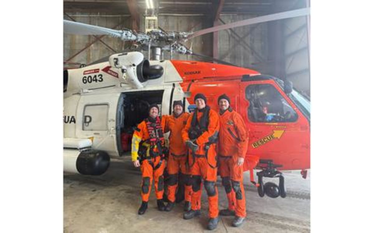 Coast Guard MH-60 Jayhawk helicopter crew posing after successful Aleutian Islands rescue mission