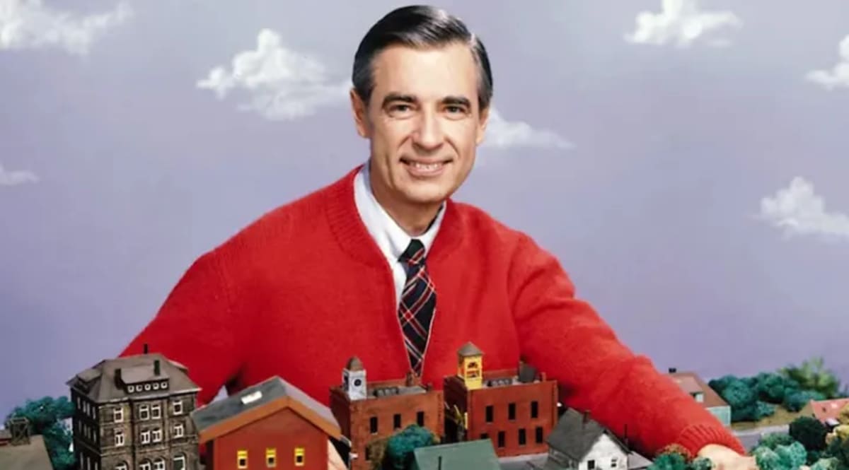 Fred Rogers smiling in his iconic cardigan sweater from Mister Rogers' Neighborhood television show