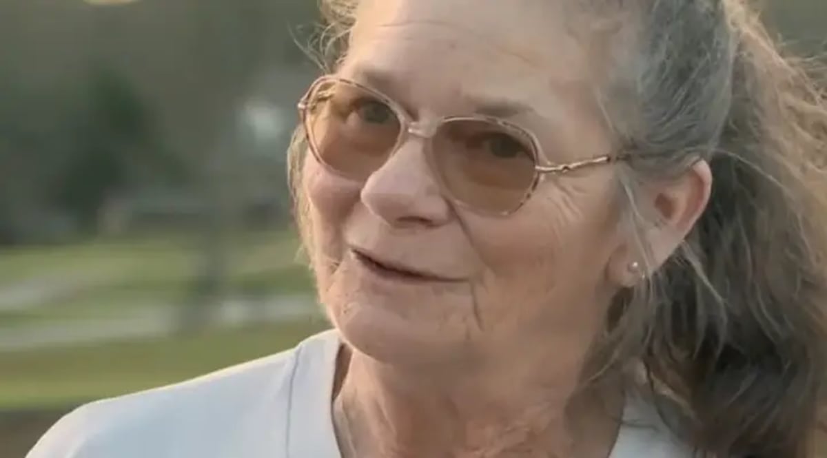 School bus driver Marlene Davis standing near her yellow school bus in Georgia