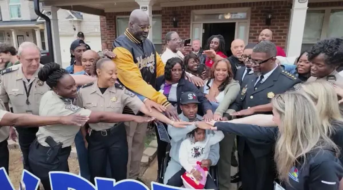 Shaquille O'Neal standing with teenage Brandon Simmons using a walker on front porch in Georgia