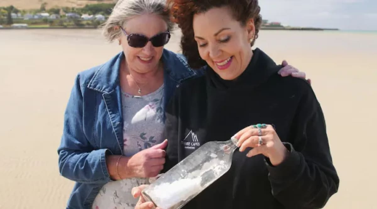 Two smiling women embrace at airport after 25-year friendship sparked by message in bottle
