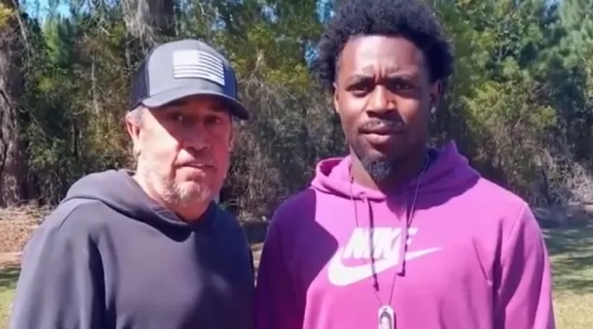 Two men pose with elderly truck crash survivor Steve Howell after heroic rescue