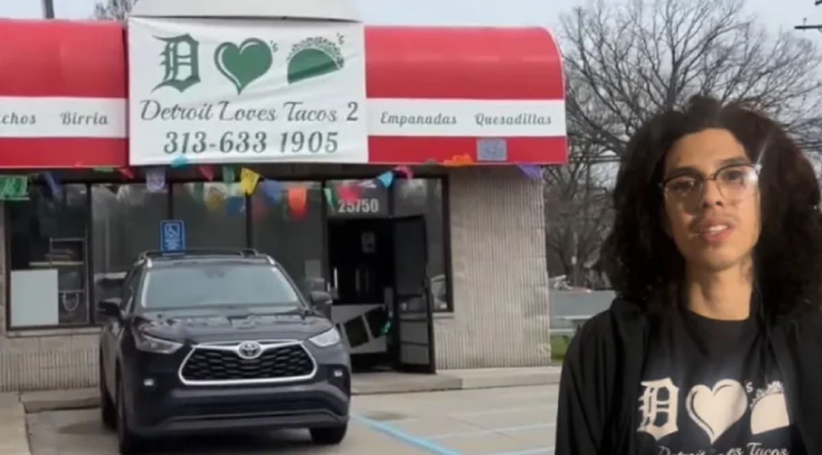Young entrepreneur Alexander Quinones smiling behind counter at Detroit Loves Tacos 2 restaurant in Michigan