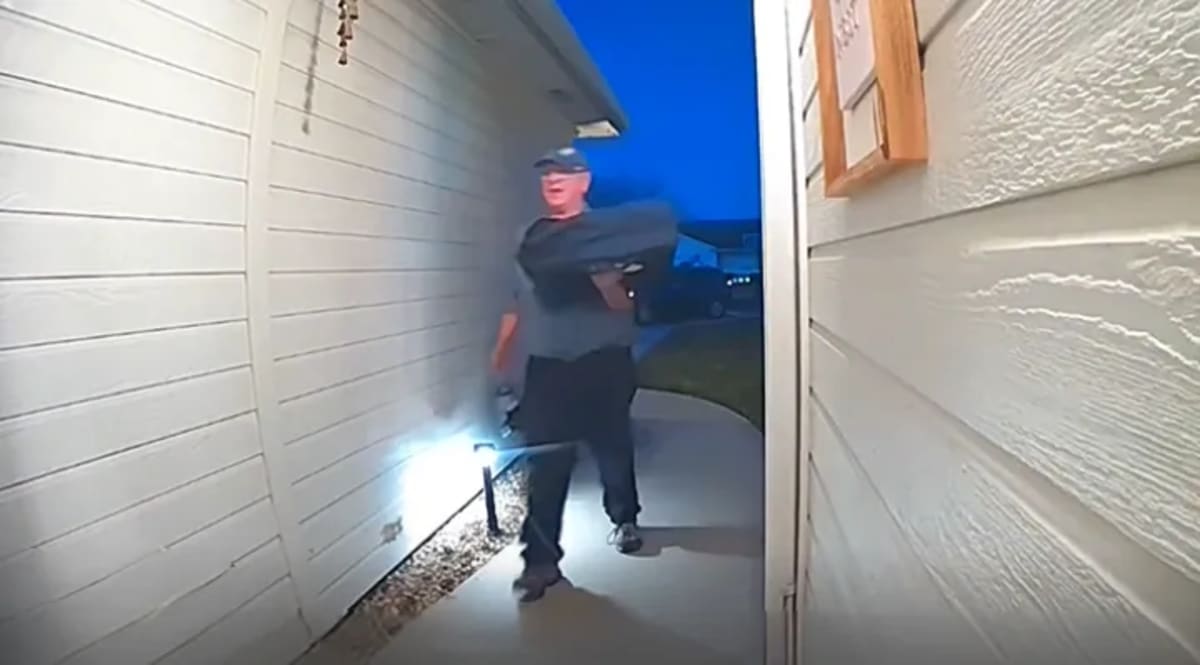 Domino's delivery driver Dan holding pizza boxes and Diet Coke at customer's door