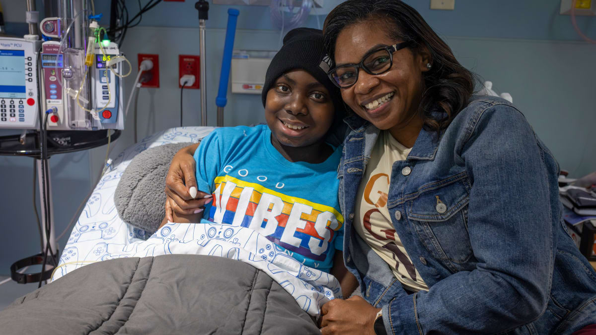 Young teen smiling in hospital bed after receiving groundbreaking sickle cell gene therapy treatment