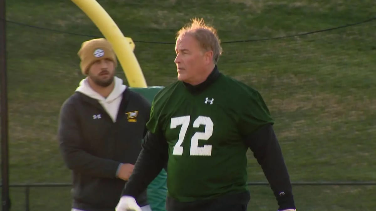 Tom Green in football gear at McDaniel College spring practice alongside younger teammates