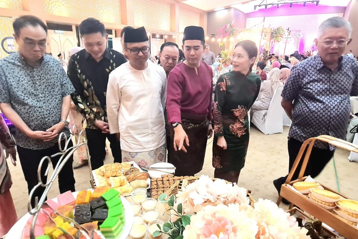 Diverse group of community members browsing traditional foods at multicultural Flora Raya festival in Sibu
