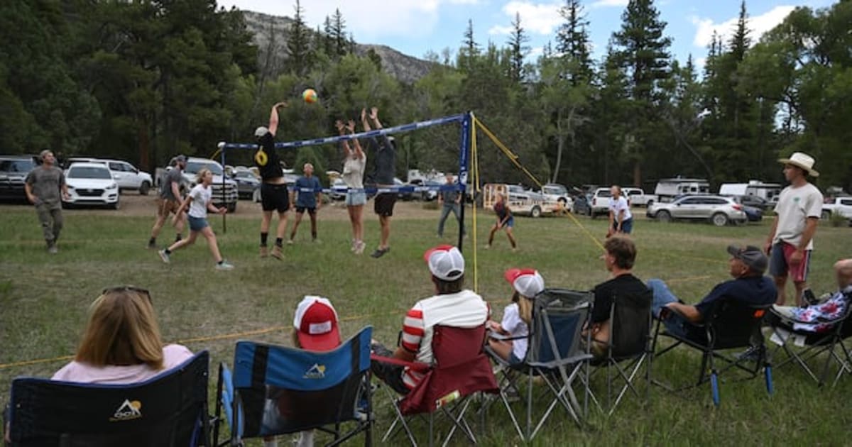 ** Large extended family playing volleyball outdoors at summer reunion in rural Utah valley