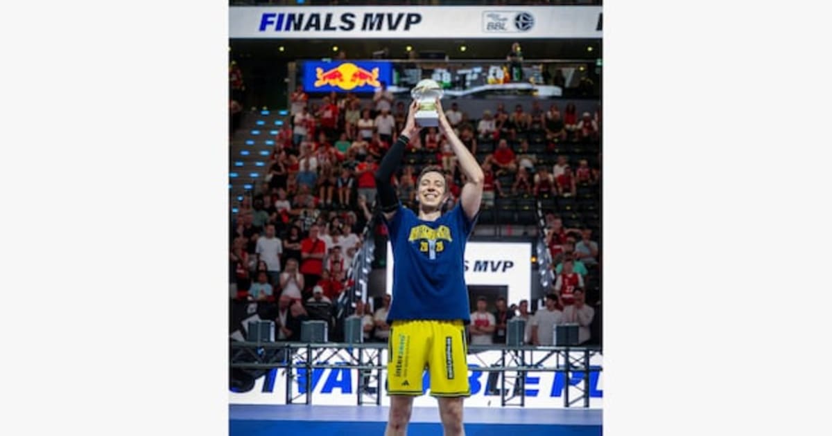 Basketball player Justin Bean holding championship trophy and Finals MVP award in Berlin
