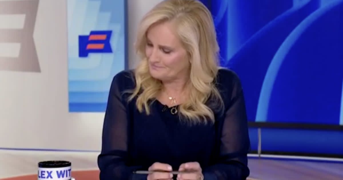 MSNBC anchor Alex Witt smiling at news desk during her final broadcast surrounded by crew